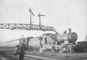 An unidentified GW Bulldog 4-4-0 passes under the signal gantry at Abbey Foregate, whilst some railway official is probably coming from the signal box.