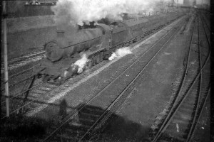 A GWR "Hall" 4-6-0 soon after passing Sutton Bridge Junction makes a start at the climb with a North to West express, Shelf Sidings are on the right.